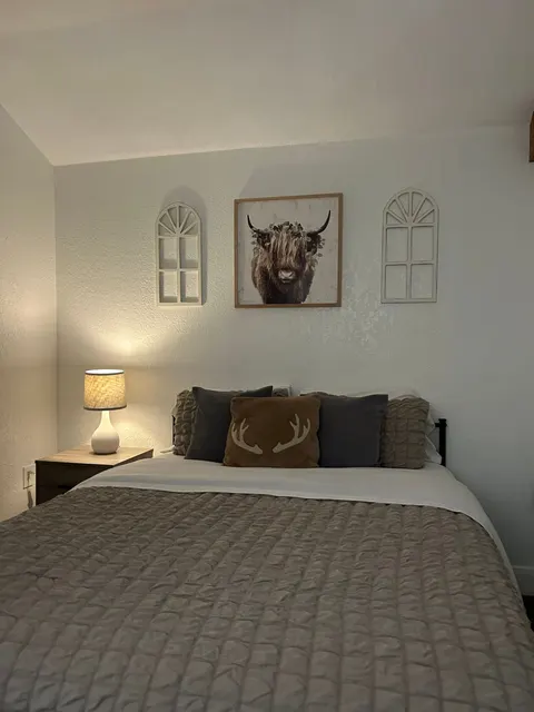 Queen bed with bedside lamps in the Cozy Cabin bedroom