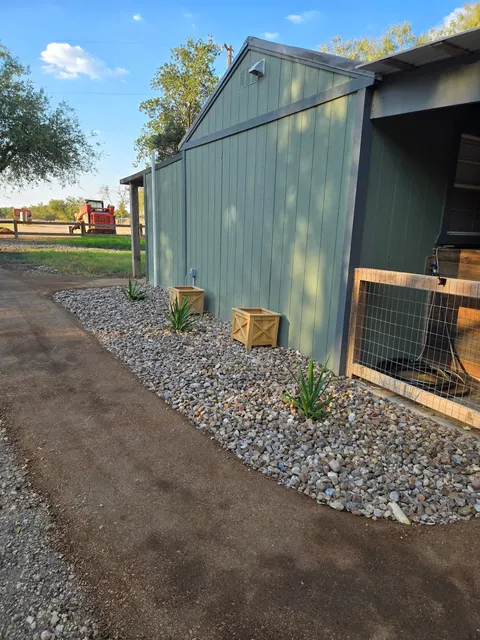 Green exterior of Cozy Cabin with a gravel border