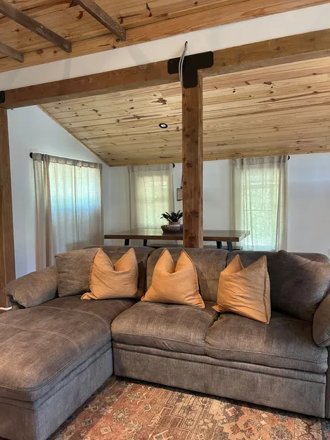 Gray sectional sofa beneath the exposed wood ceiling in the 1914 HideAway living room