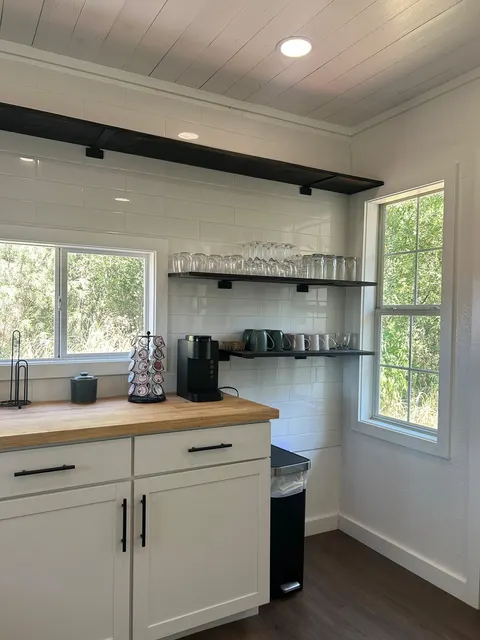White kitchen cabinets and wooden countertop at 1914 HideAway