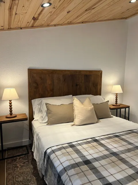 Queen bed with bedside lamps in the 1914 HideAway bedroom