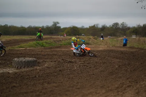 Several riders sharing the Creekside track, with a yellow-helmeted rider on an orange number 17 bike in the foreground